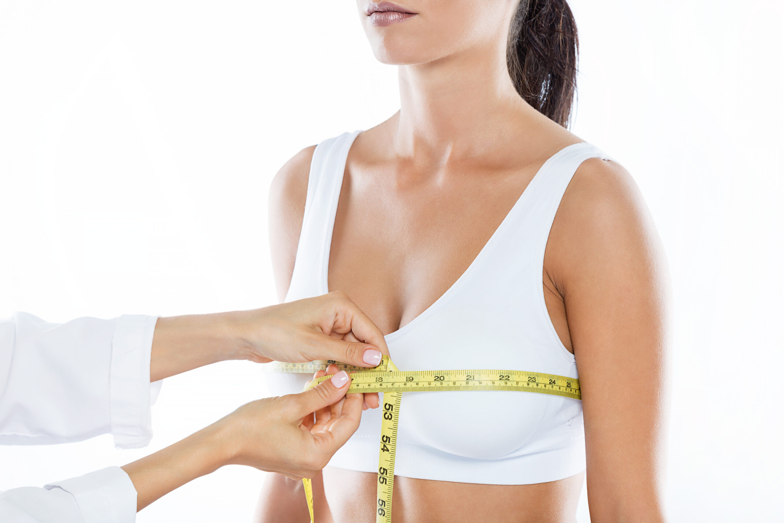 doctor with measure tape measuring size patient s breast scaled