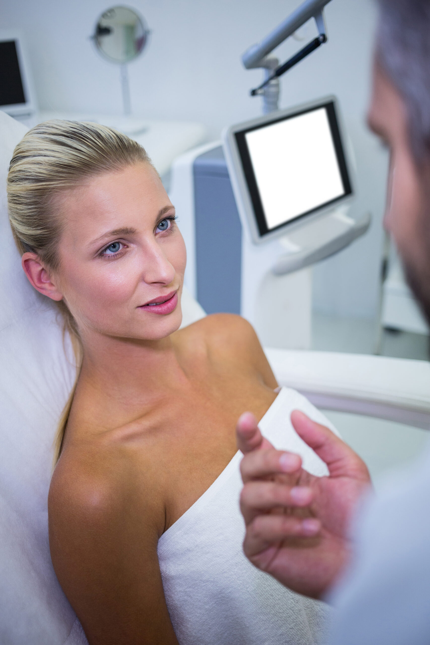 female patient lying looking doctor scaled