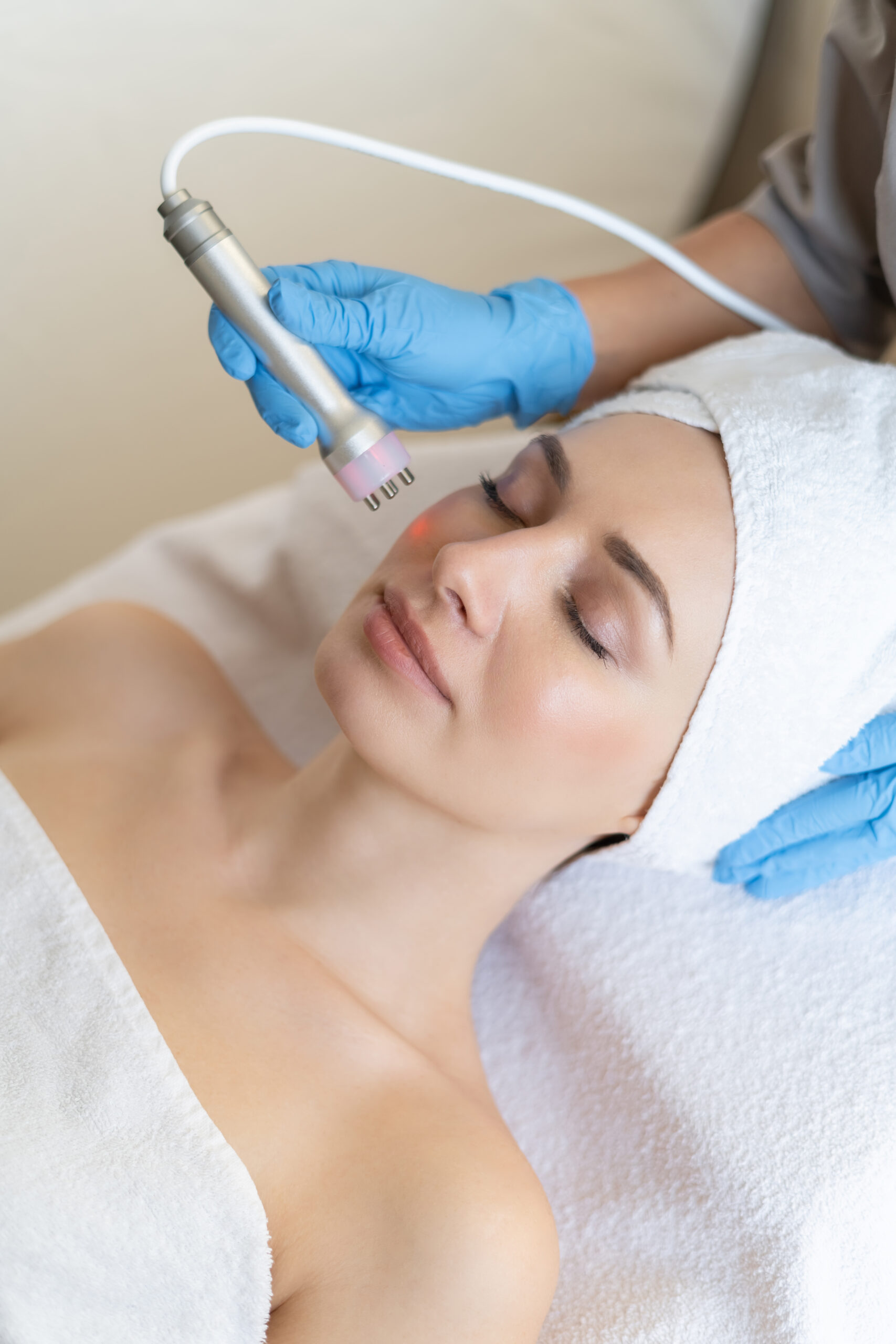 young woman lying cosmetologist s table rejuvenation procedure cosmetologist take care about neck face skin youthfull wellness hardware face cleaning procedure scaled